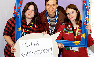 Drei junge Leute mit einer Sprechblase vor sich haltend.